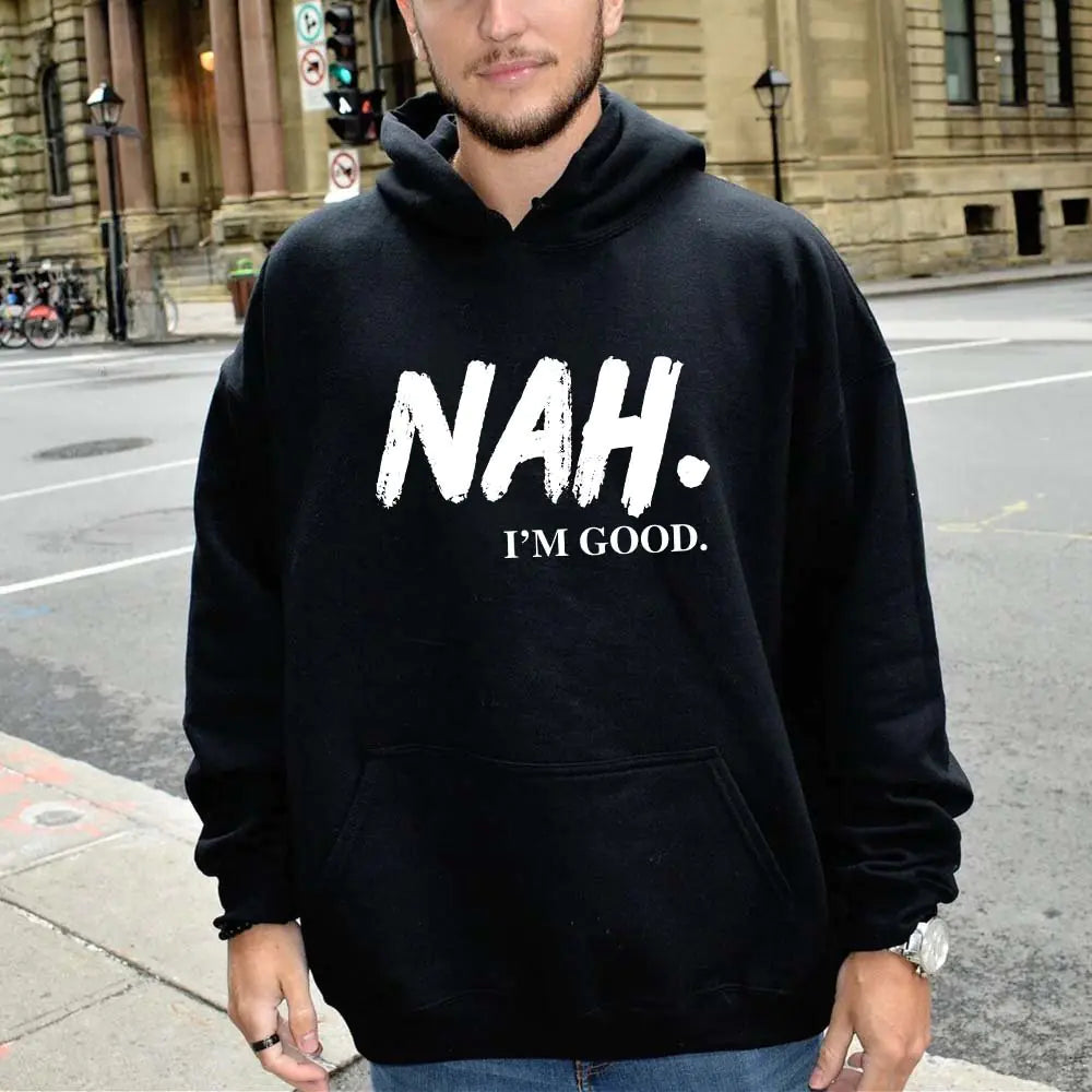 Person wearing a black hoodie with 'NAH. I'M GOOD.' text on a city street.
