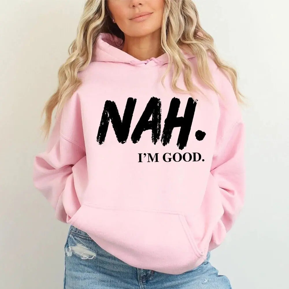 Person wearing a pink hoodie with 'NAH. I'M GOOD.' text on a plain background