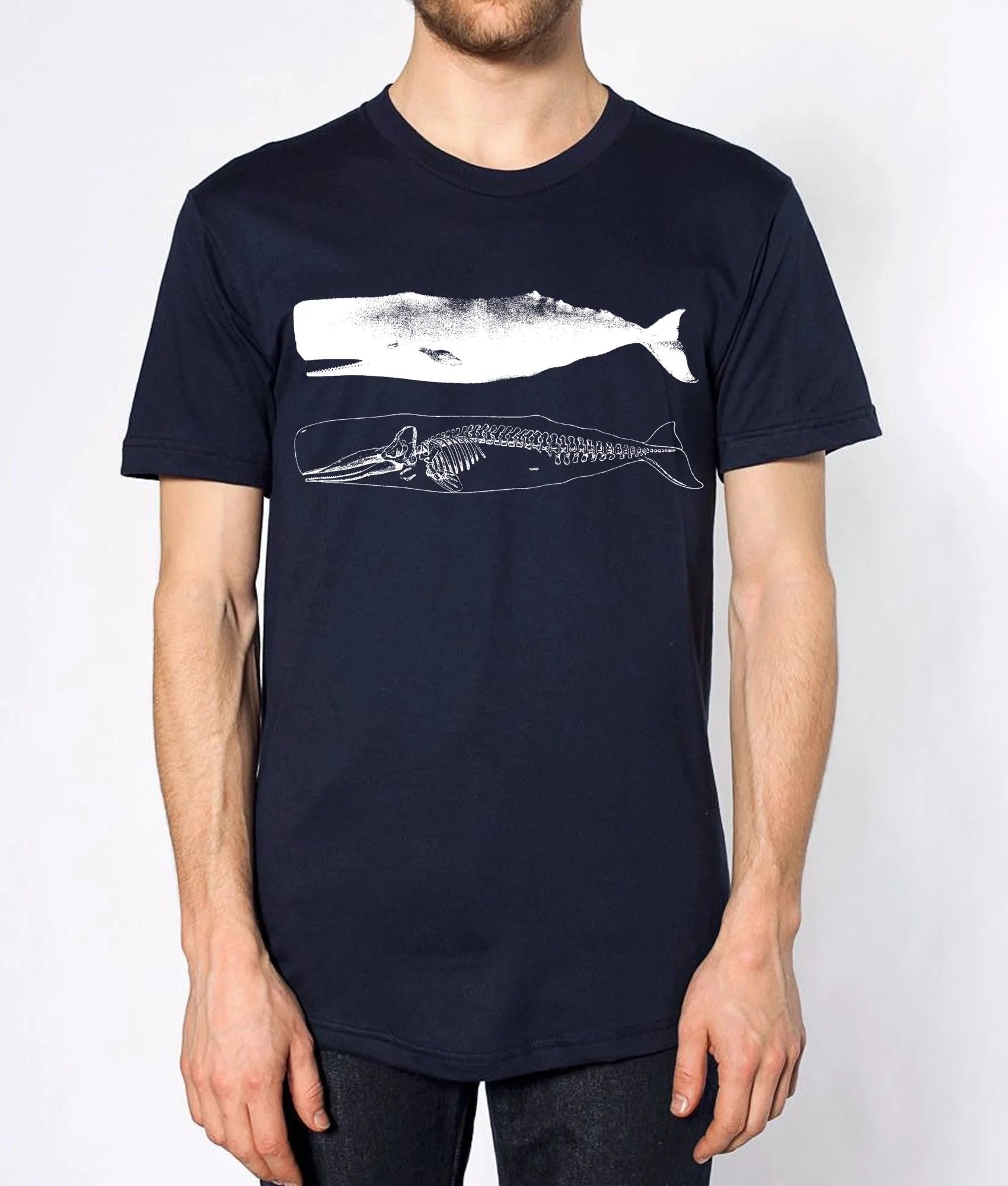 Person wearing a navy blue t-shirt with a white whale skeleton design on a plain background