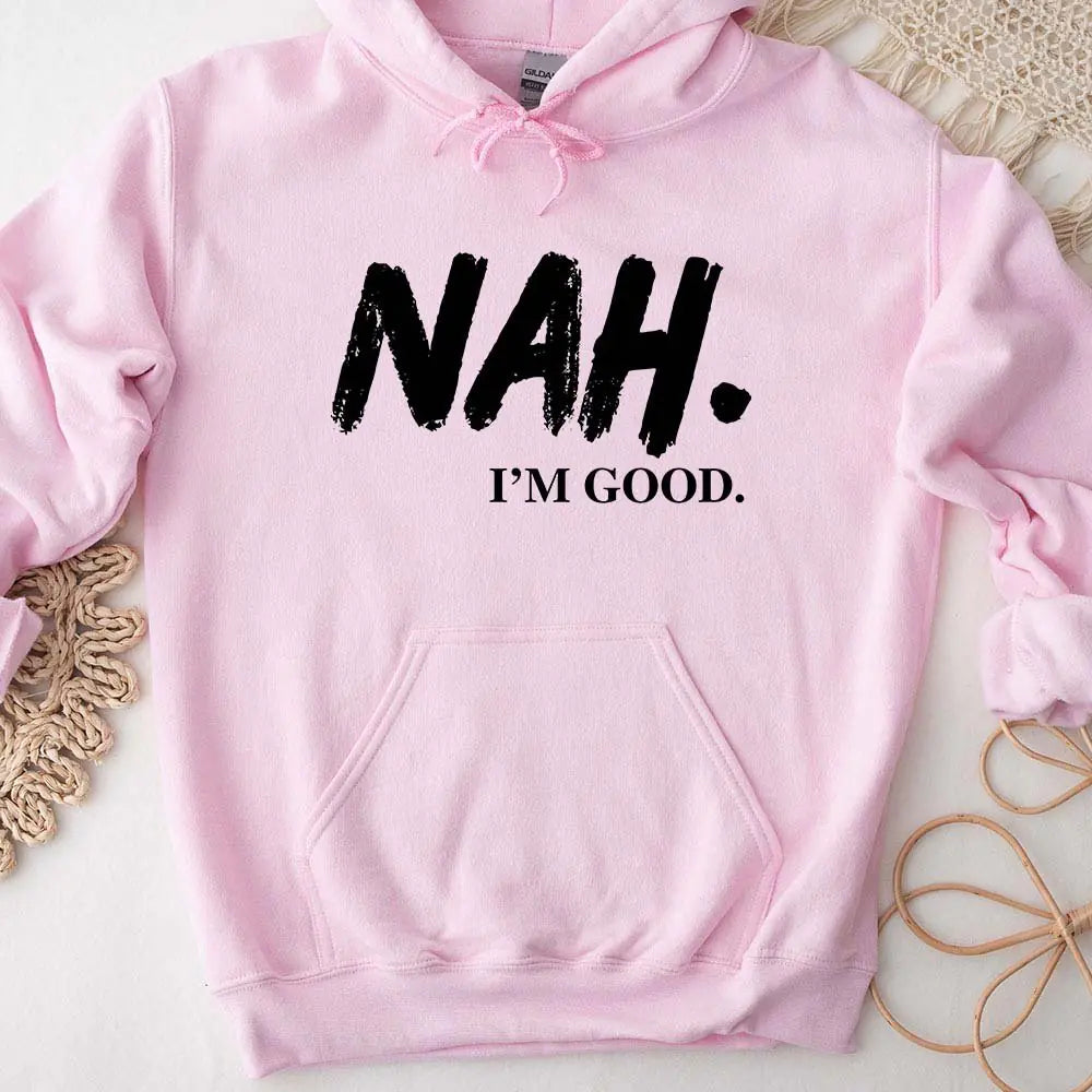 Pink hoodie with 'NAH. I'M GOOD.' text on a light background